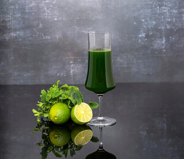 Fotografía de fondo de jugo de vegetales verdes vaso de menta fresca de lima sobre un fondo oscuro