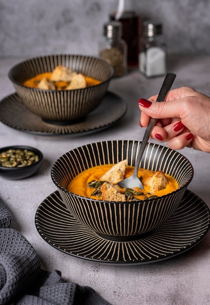 Fotografía gastronómica de sopa de calabaza y tostadas