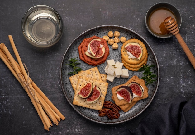 Fotografía gastronómica de vino, queso blando, salami, higos.