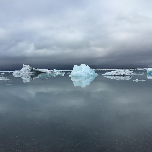 Fotografia idílica de icebergs em um lago contra um céu nublado