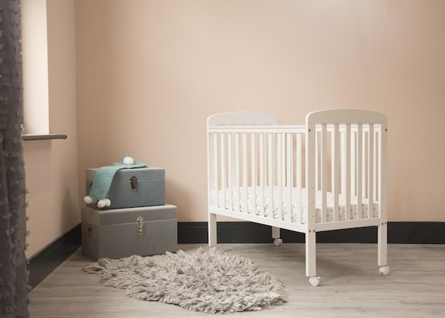 Fotografía del interior minimalista y soleado de la habitación de los bebés con la cama de los niños