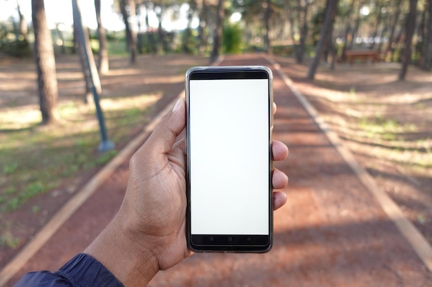 Fotografía de un joven usando un teléfono inteligente al aire libre