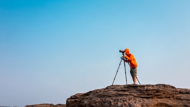 Fotografía de la libertad imágenes de archivo disparando el trípode de la cámara en la roca de la montaña en sam phan bok ubon Ratchathani Tailandia fondo de cielo azul aislado