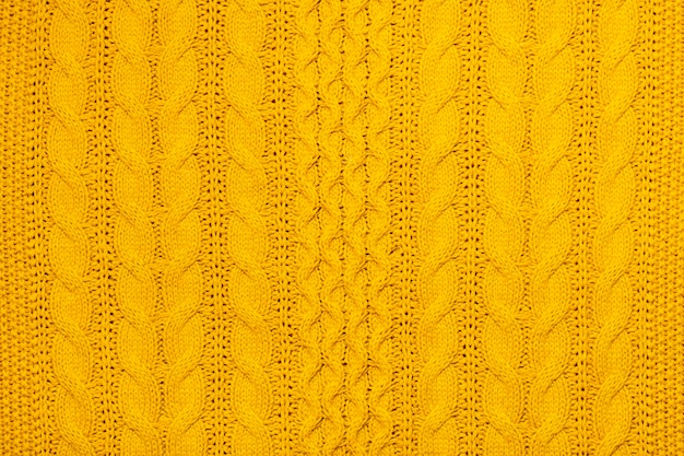Fotografía macro amarilla brillante de jersey texturizado y tejido de suéter o sudadera Patrón y fondo para el concepto de otoño cálido de moda