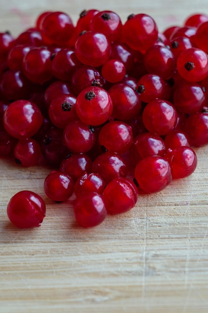 Fotografía macro de bayas de grosella roja sobre una mesa de madera