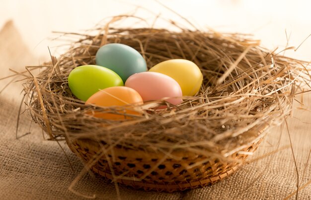 Fotografía macro de coloridos huevos de Pascua en nido sobre la mesa