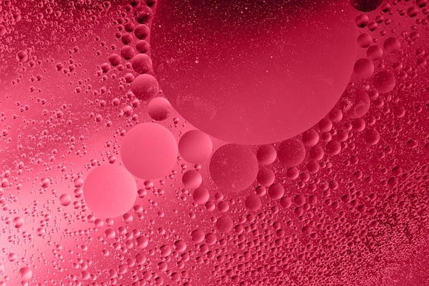 Fotografia macro das gotas de óleo na superfície da águaCor vermelha monocromática