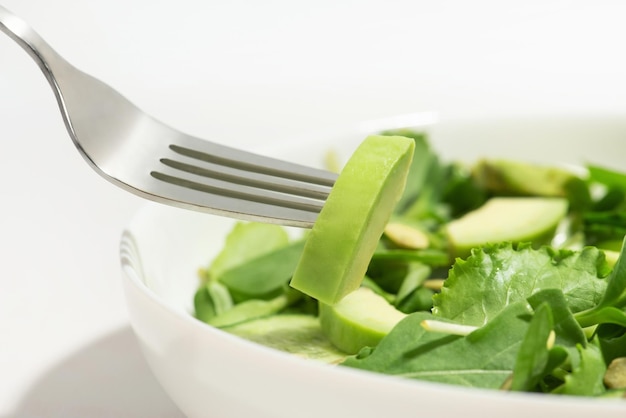 Fotografía macro de ensalada con aguacate en un tenedor