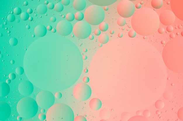 Fotografia macro óleo sobre água de fundo gradiente de cor verde e rosa abstrato