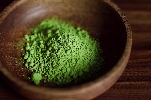 Fotografía macro de polvo de té verde matcha en un cuenco de madera