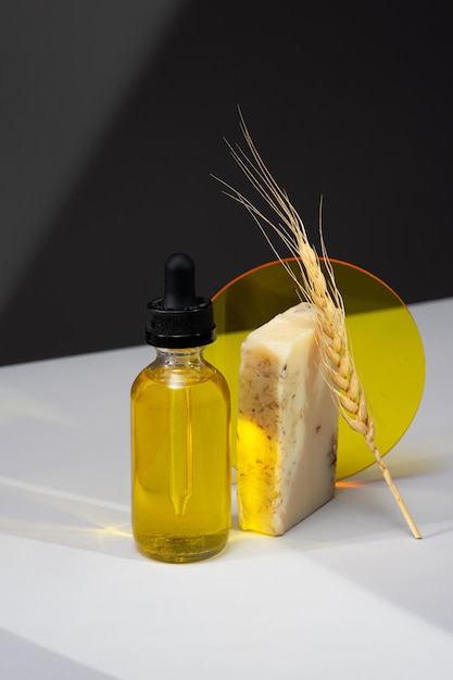 Fotografía minimalista creativa con cosméticos para el cuerpo y el cabello de la piel Una botella de aceite de suero y jabón hecho a mano sobre un fondo gris oscuro Concepto de autocuidado y productos orgánicos Proyección isométrica