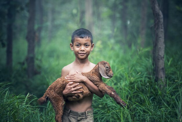 Fotografía de un niño indonesio sosteniendo un perro