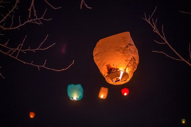 Fotografía nocturna de una linterna de deseos volando hacia el cielo