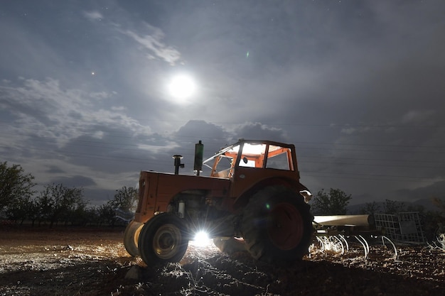 Fotografia noturna de um trator abandonado