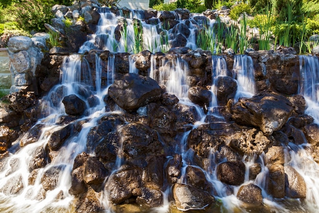 Fotografía de paisaje, una hermosa cascada entre las piedras que fluyen agua ligera