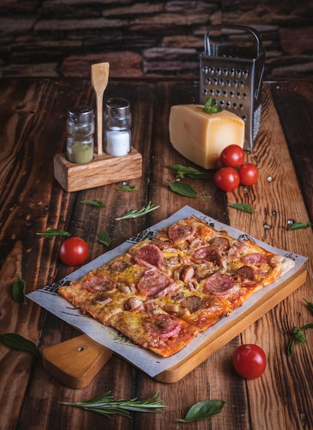 Fotografía de Pizza en una mesa de madera con ingredientes frescos, por Yuri Ugarte Cespedes