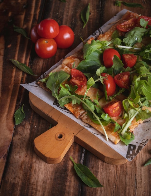 Fotografía de Pizza en una mesa de madera con ingredientes frescos, por Yuri Ugarte Cespedes