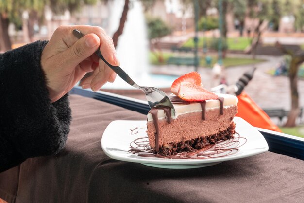 Fotografía de postre de chocolate con fruta y helado.