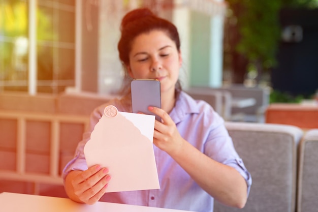 Fotografía de primer plano de la fotografía femenina del sobre de invitación con sello de cera y tarjetas en blanco