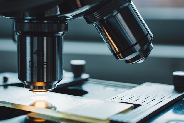 Fotografía en primer plano de un microscopio con lente metálica en el laboratorio