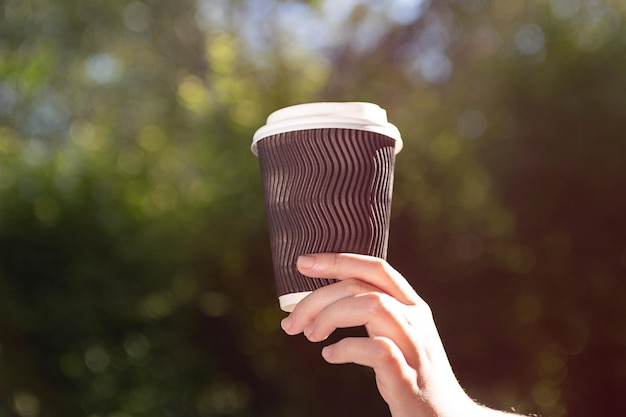 Fotografía de primer plano de una mujer sosteniendo una taza de café en la mano Lugar para el logotipo