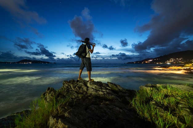 Fotografia profissional nas pedras no céu dramático do pôr do sol ou do nascer do sol sobre o mar tropical em phuket tailândia