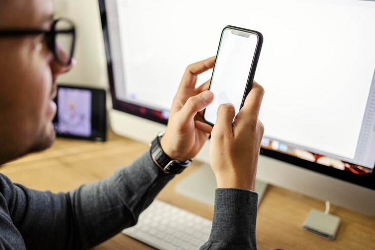 Foto fotografía recortada de un joven con un teléfono móvil en las manos y escribiendo en él