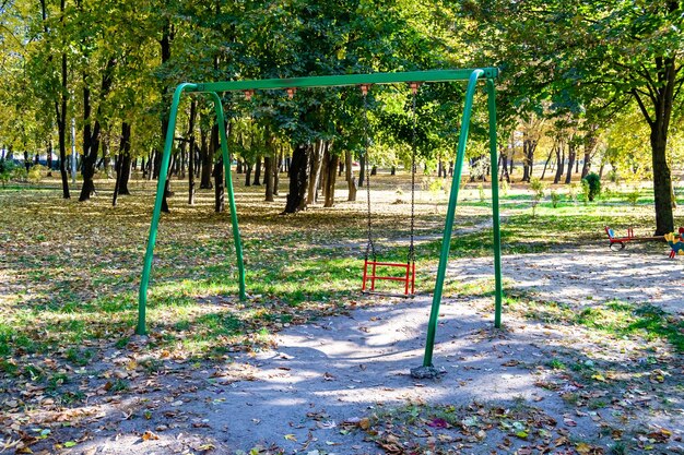 Fotografía sobre el tema del patio de recreo vacío con columpio de metal para niños.