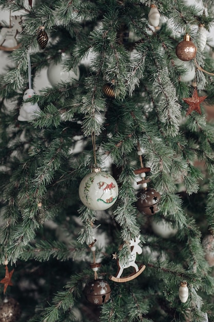 Fotografía de Stock de hermoso árbol de Navidad decorado con bolas azules y plateadas y blancas y regalos de Navidad envueltos bajo el árbol. Dos figuras de Papá Noel debajo de un árbol.