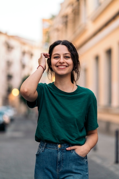 Fotografía de Stock de una mujer joven mirando a la cámara sonriendo. Lleva gafas.