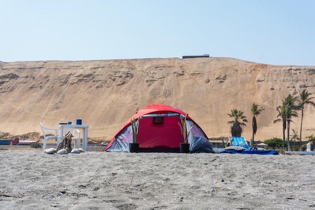 Fotografía de una tienda de campaña roja en la playa en la playa por Yuri Ugarte Cespedes