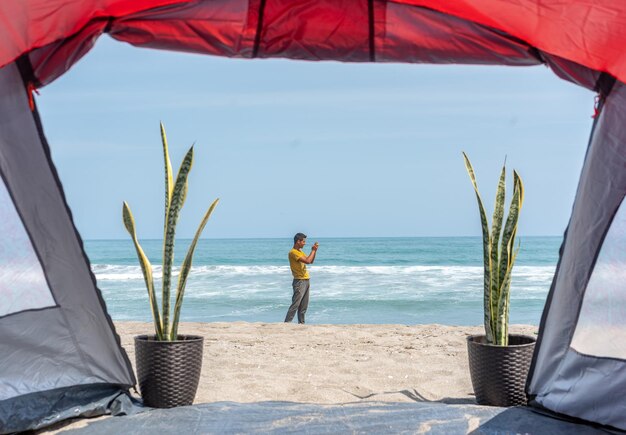 Fotografía de una tienda de campaña roja en la playa en la playa por Yuri Ugarte Cespedes