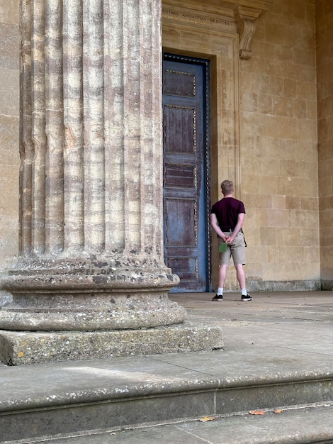 Foto fotografía trasera de un turista admirando un antiguo edificio griego