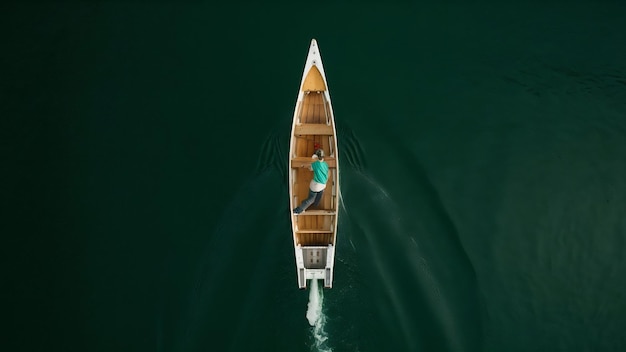 Fotografia vertical de um homem em um barco e as marcas quadradas na superfície