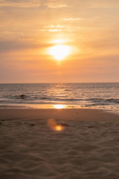 Fotografia vertical do belo pôr-do-sol na praia de Scheveningen, na Holanda