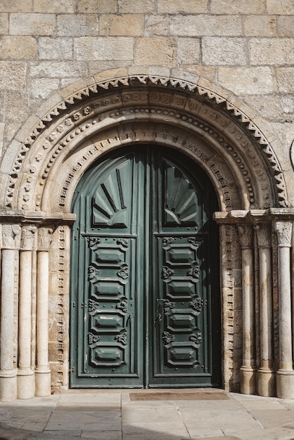 Fotografía vertical de una vieja puerta verde bajo un hermoso arco en Caminha Portugal