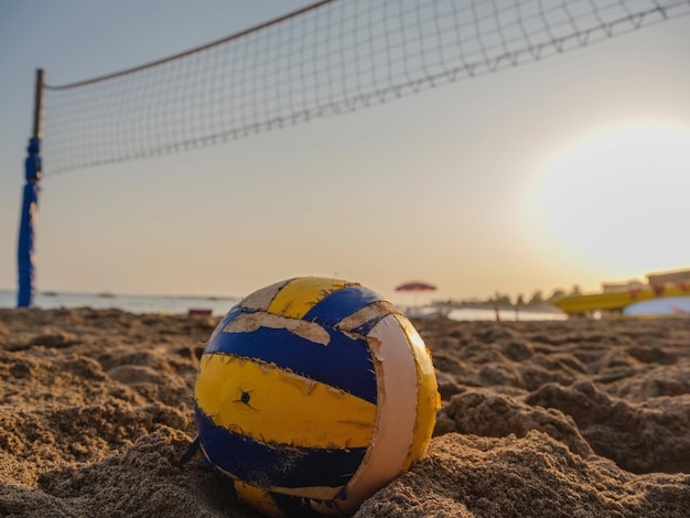 Foto fotografía de voleibol de playa en la playa de arena durante la puesta de sol