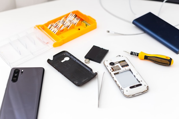 Fotografías de primeros planos de teléfonos móviles en un taller de reparación.