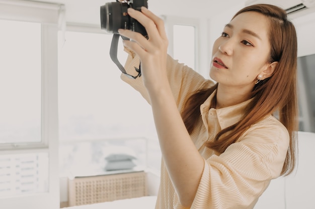 Fotografin, die den Kamerasucher in ihrer eigenen Wohnung überprüft.