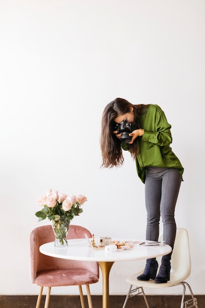 Fotografin fotografiert Schönheitsprodukte auf dem Tisch