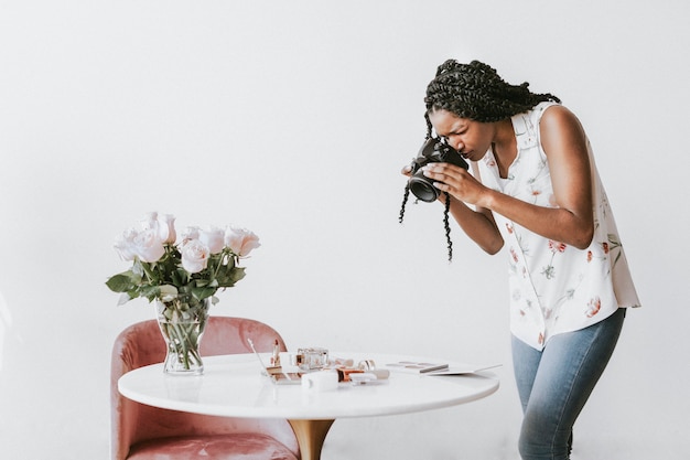 Fotografin fotografiert Schönheitsprodukte auf dem Tisch