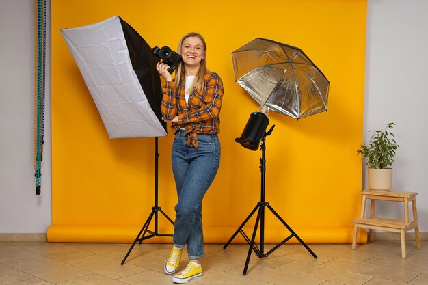 Fotografin im Fotostudio mit Studioausrüstung in der Nähe