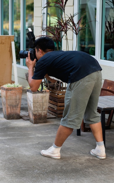 Fotografmann, der steht und ein DSLR-Foto macht.