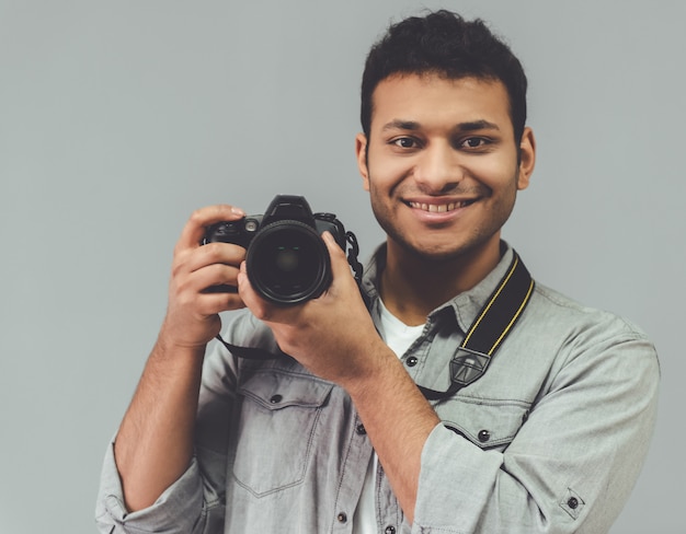 Fotógrafo afro posa con su cámara