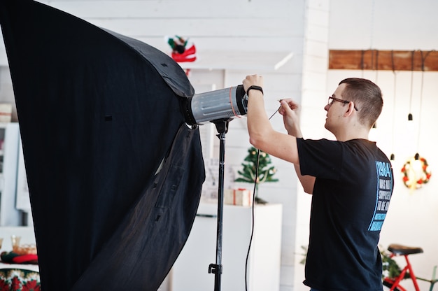 El fotógrafo ajusta la luz del flash en el estudio.