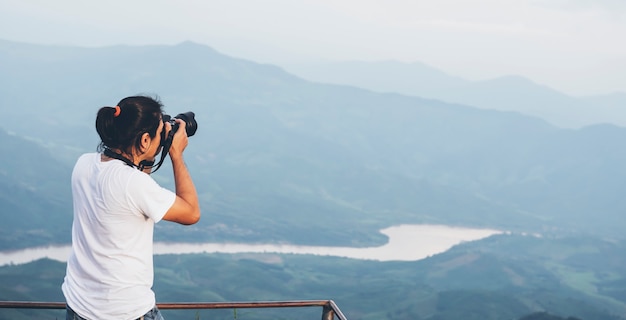 Un fotógrafo asiático está fotografiando una montaña, una atracción turística popular en Tailandia