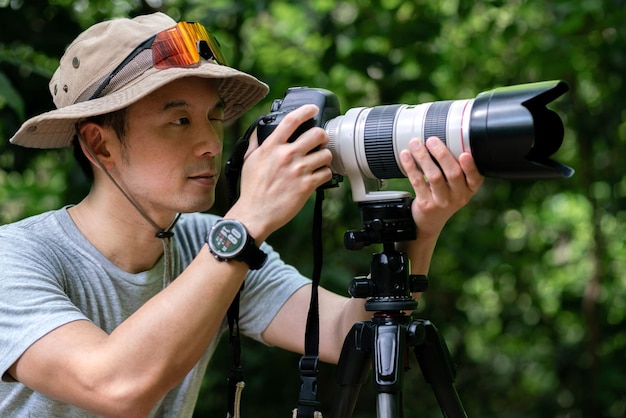 Fotógrafo asiático viaja e tira fotos com câmera de lente e trilha de mochileiros trekking na natureza