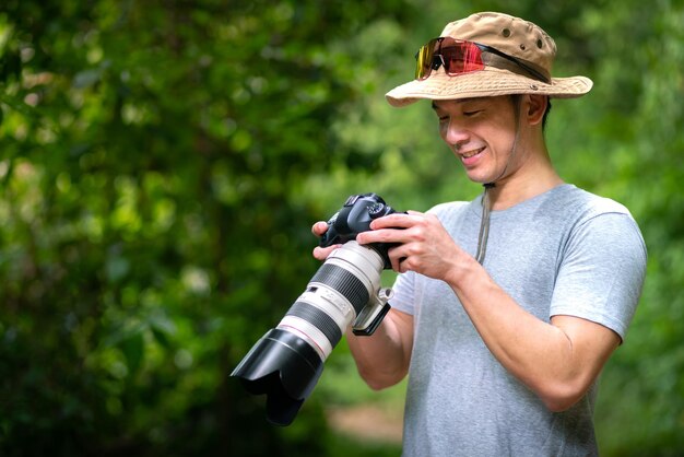 fotógrafo asiático viaja e tira fotos com câmera de lente e trilha de mochileiros trekking na natureza