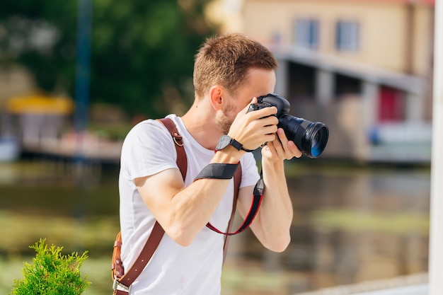 El fotógrafo barbudo hace una foto con una cámara digital. de cerca