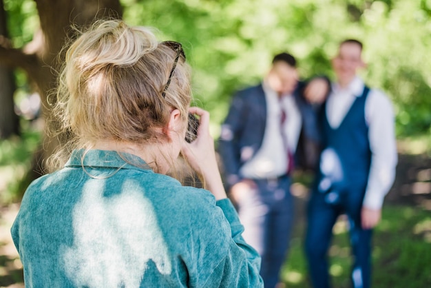 El fotógrafo de bodas fotografía a los invitados de los novios en la naturaleza